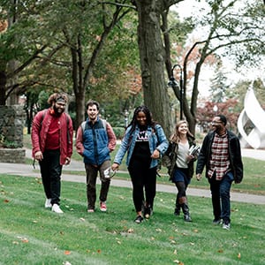 Students walking across the grass on campus